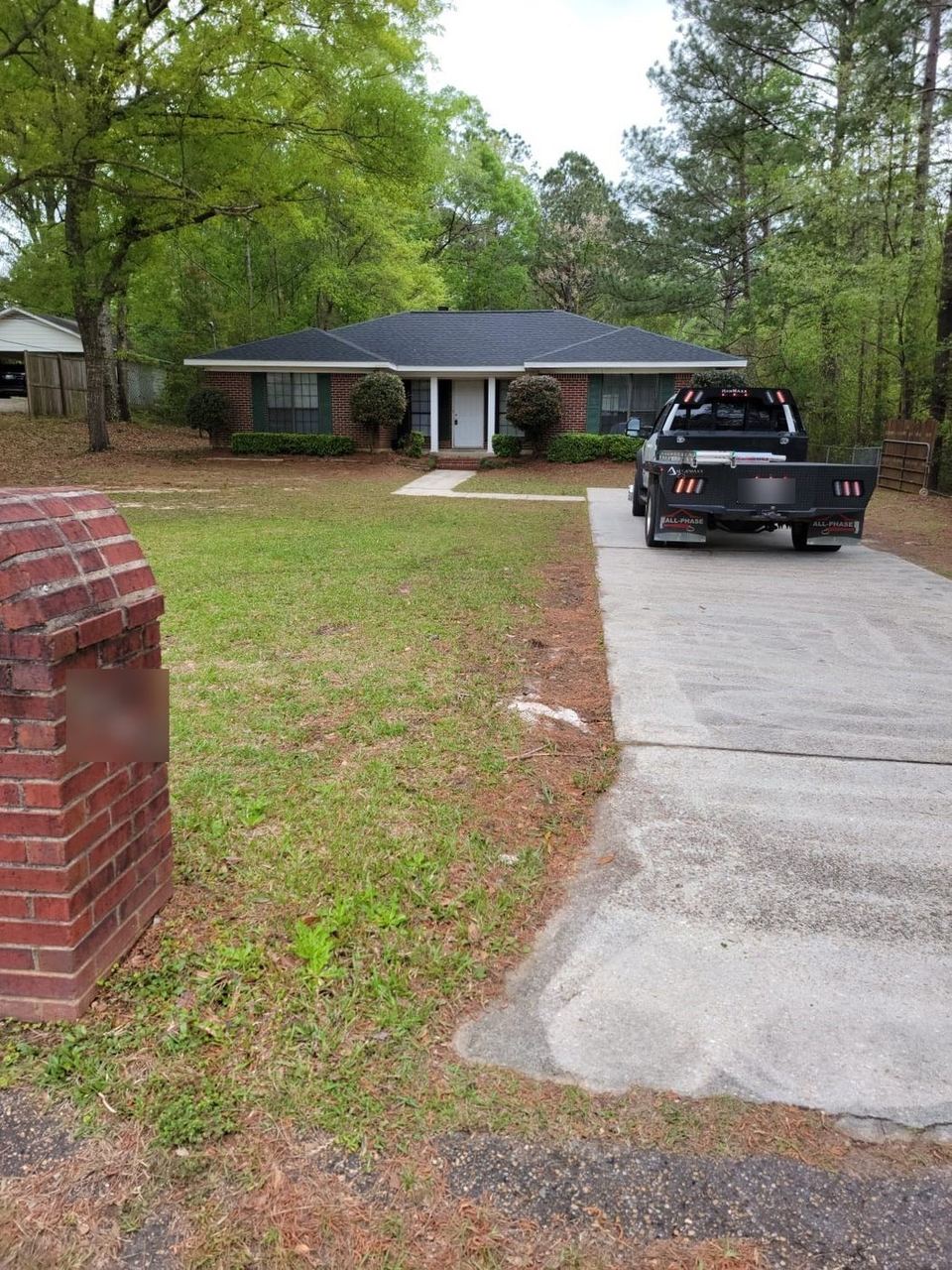 Completed architectural shingle roof on a brick ranch home with the A&W truck in the driveway